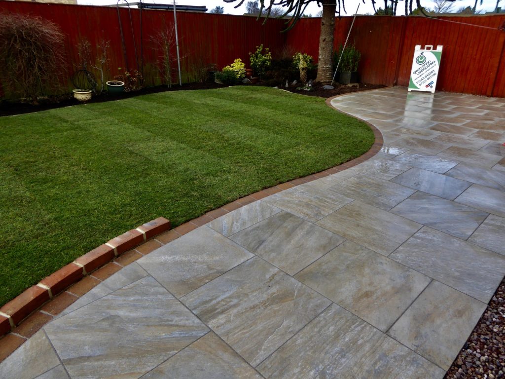 Porcelain paving patio with curved lawn edging and landscaped garden in Stockton, Teesside by Green Onion Landscaping